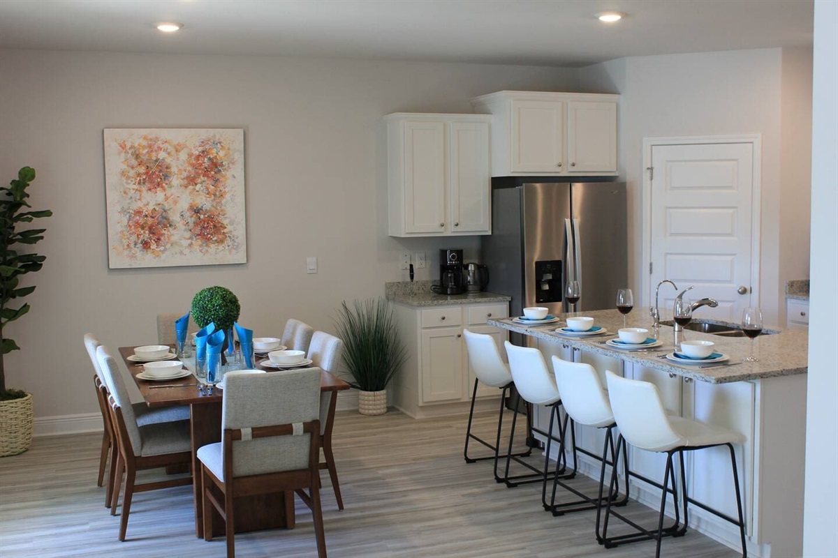 Fully equipped modern kitchen with dining area, spacious counters, and a sleek 2-door fridge