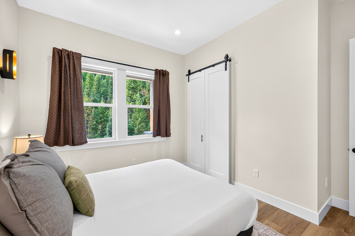 View out the side window of bedroom 2 with a queen bed.