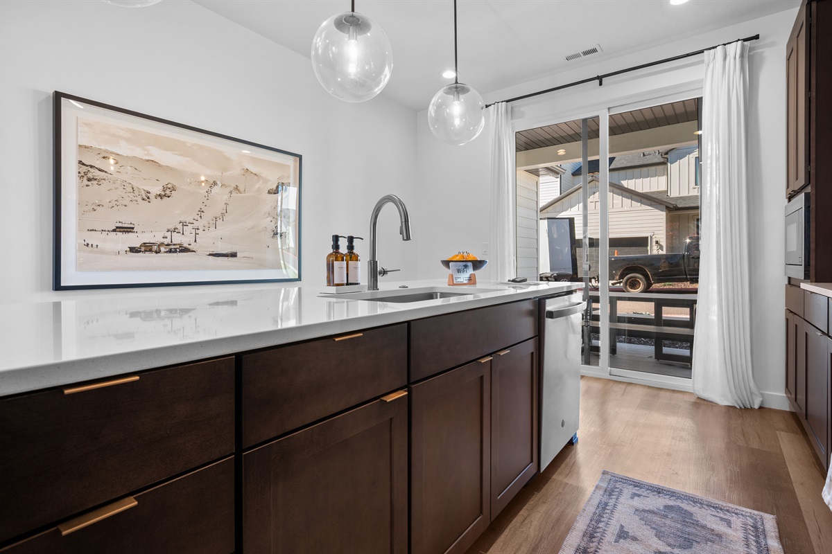 The bright kitchen island is the heart of the home, framed by mountain-inspired artwork and natural light.