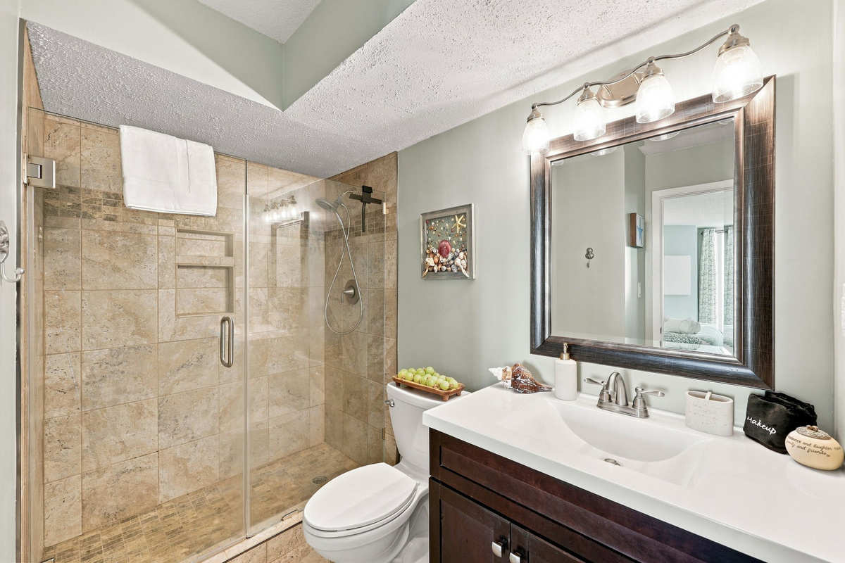 Freshen up after a day at the beach in this crisp, modern bathroom equipped with a walk-in shower and plenty of counter space.