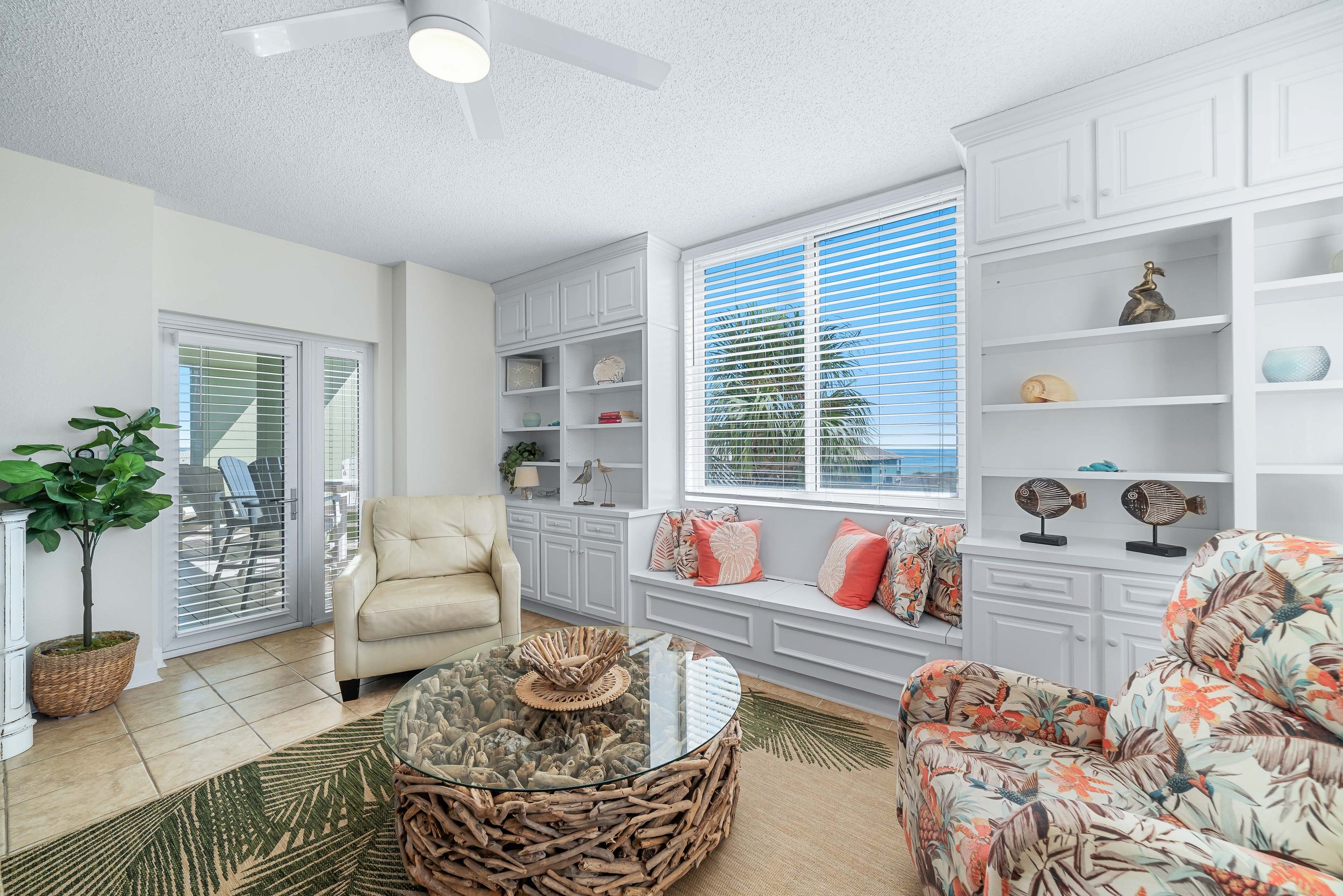Discover this inviting seating area in the Primary bedroom featuring custom built-in shelving, a comfortable window seat, and unique decorative touches.