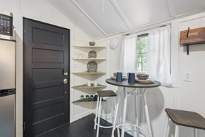 Small dining table with 2 chairs and loon themed dishes.