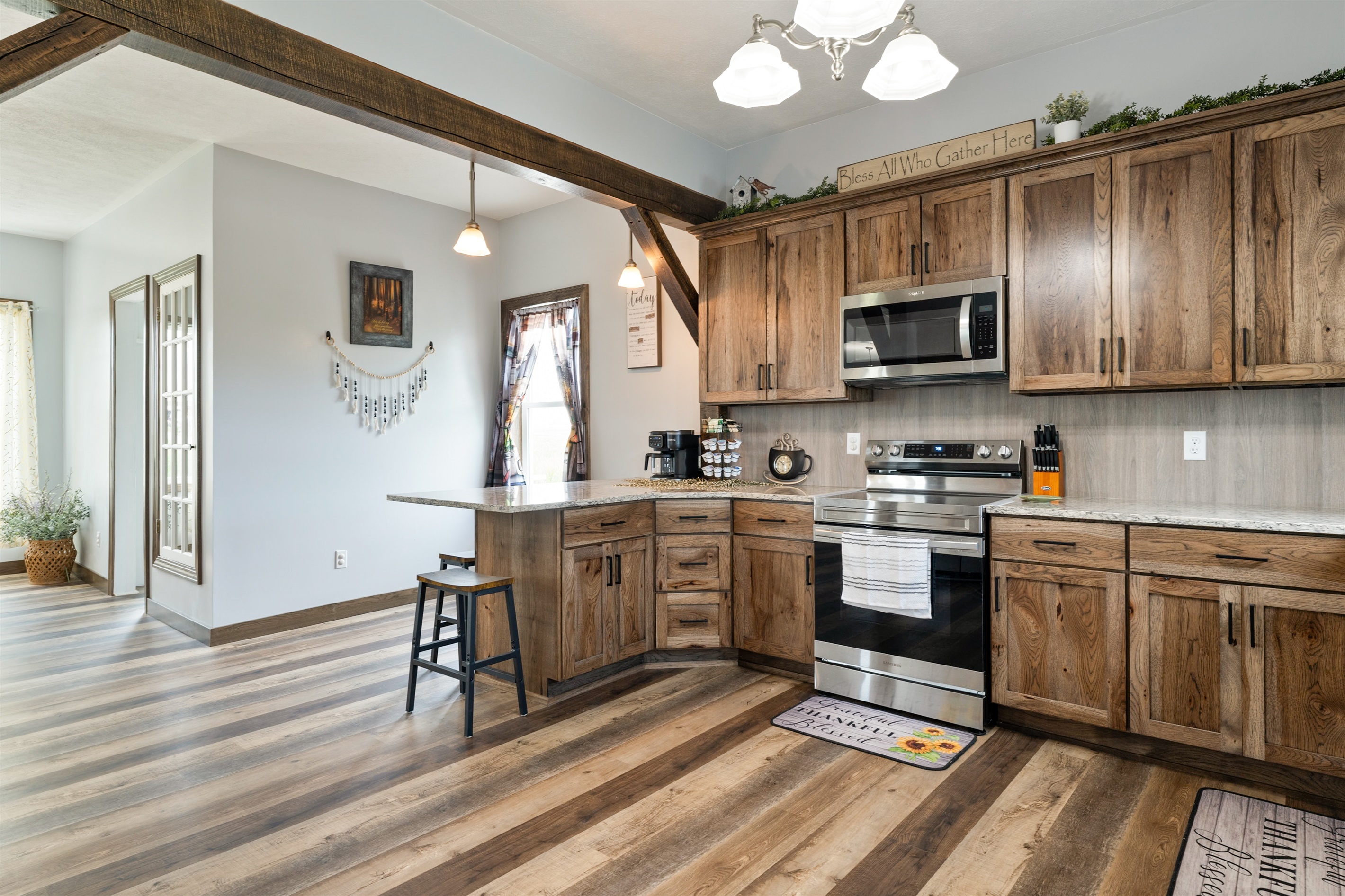 Beautiful farmhouse-style kitchen with warm wood cabinetry, granite counters, and a spacious island with bar seating for four.