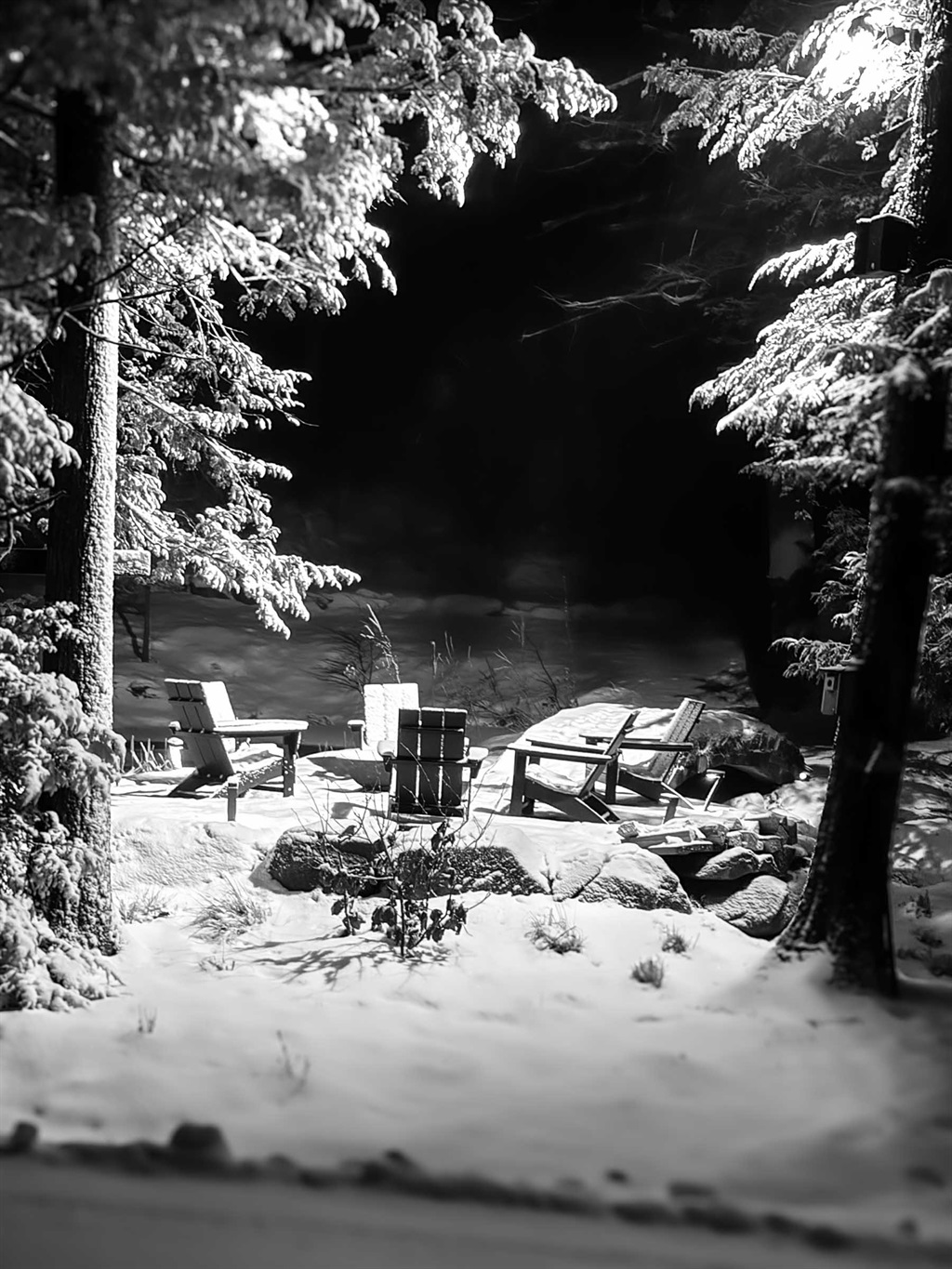 Snow-covered fire pit at the pond at Sunset Falls Estate after a winter storm
