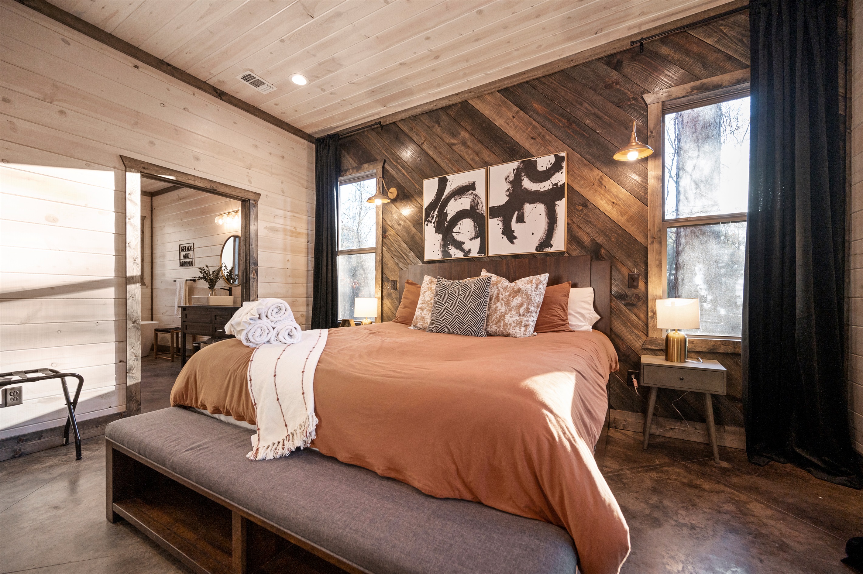 Cozy rustic retreat with a king bed, warm wood accents, and serene forest views.
