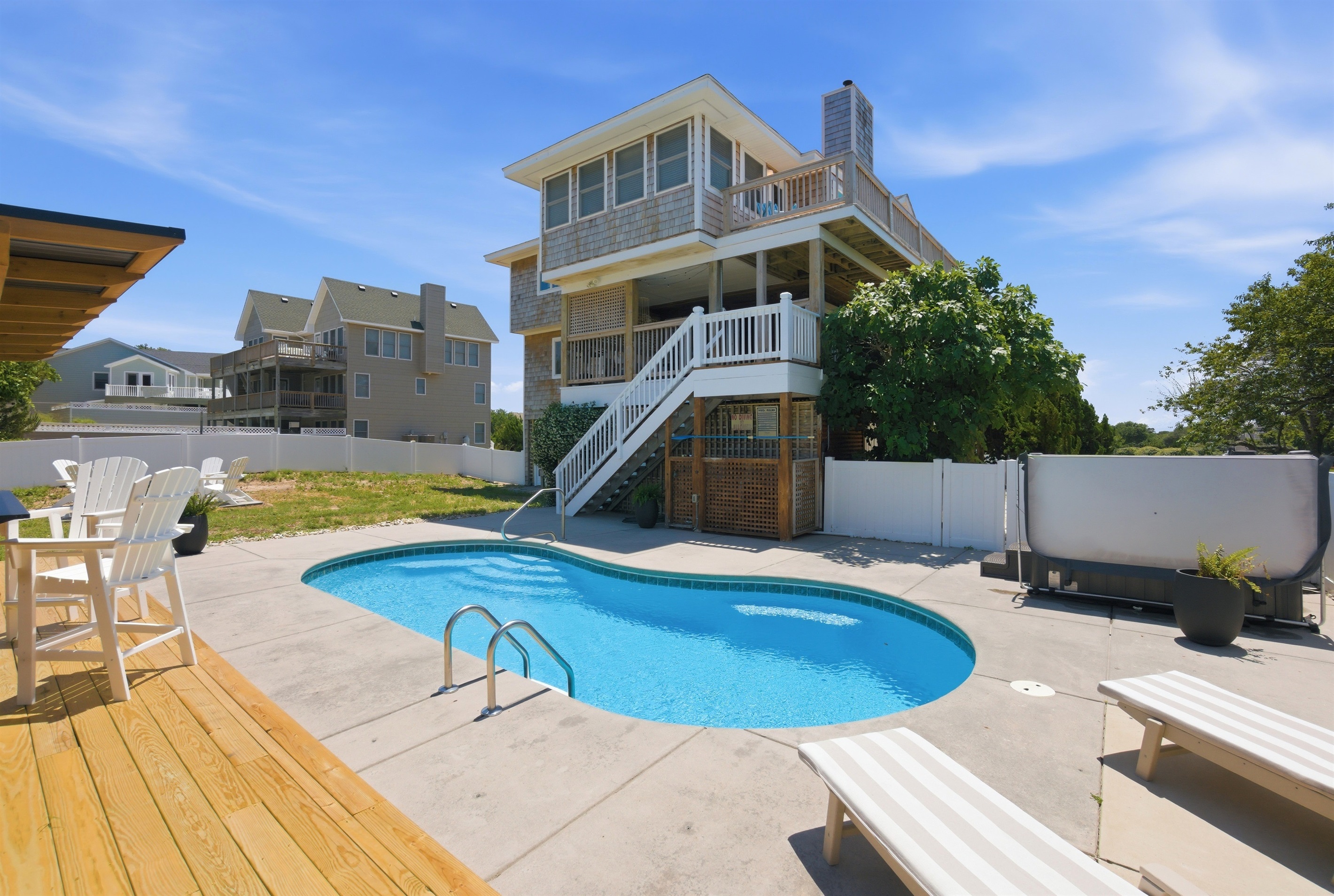 Private backyard pool area with lounge seating and fenced yard