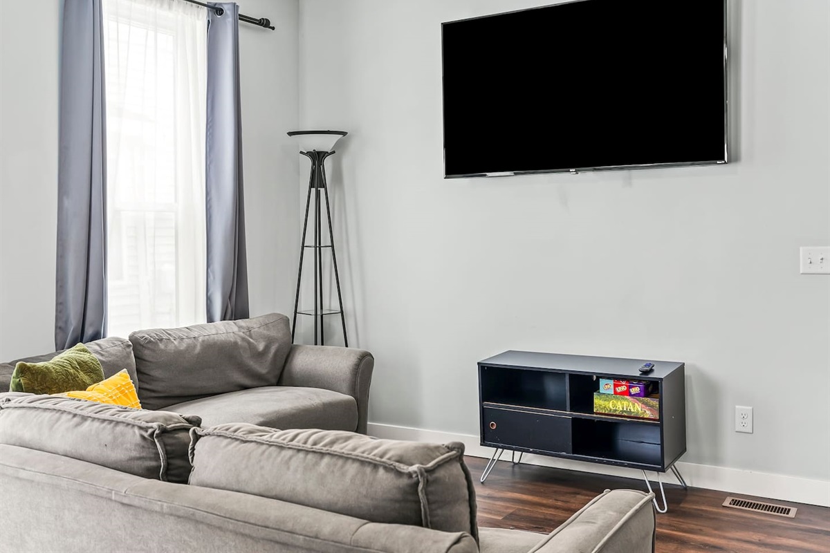 Comfortable living area with ample seating, stylish floor lamp, and easy access to the rest of the apartment.