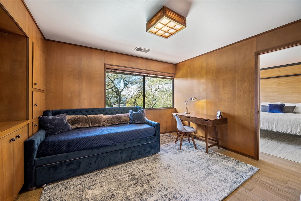 The primary suite has a library nook with a twin daybed. There are two twin mattress - one on top and one that rolls out from underneath the daybed.