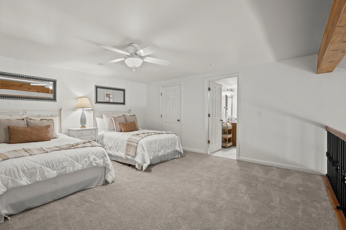 Relax in the spacious guest loft of our Cotton Bayou condo, featuring two double beds, a smart TV for entertainment, and a cozy atmosphere. Perfect for family or friends to unwind after a day at the pool or out on the water.