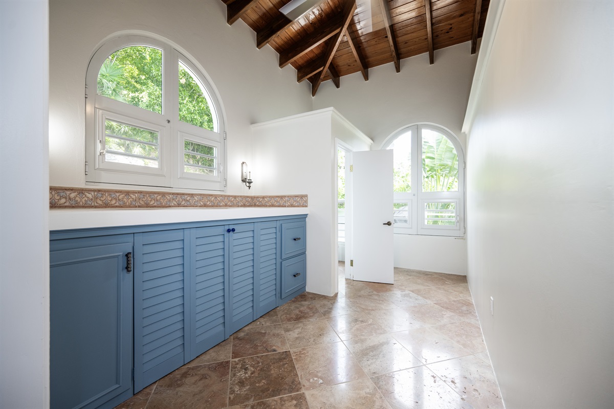 Laundry area is located just off the open living area. The washer and dryer are inside the blue cabinets. At the end of the hallway is the half bathroom