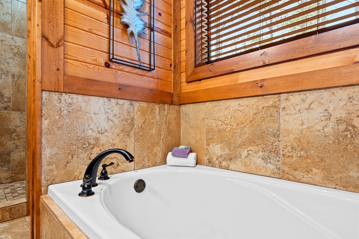 A closer view of the tub shows the cozy wood surroundings that create a spa-like feel right inside the cabin.