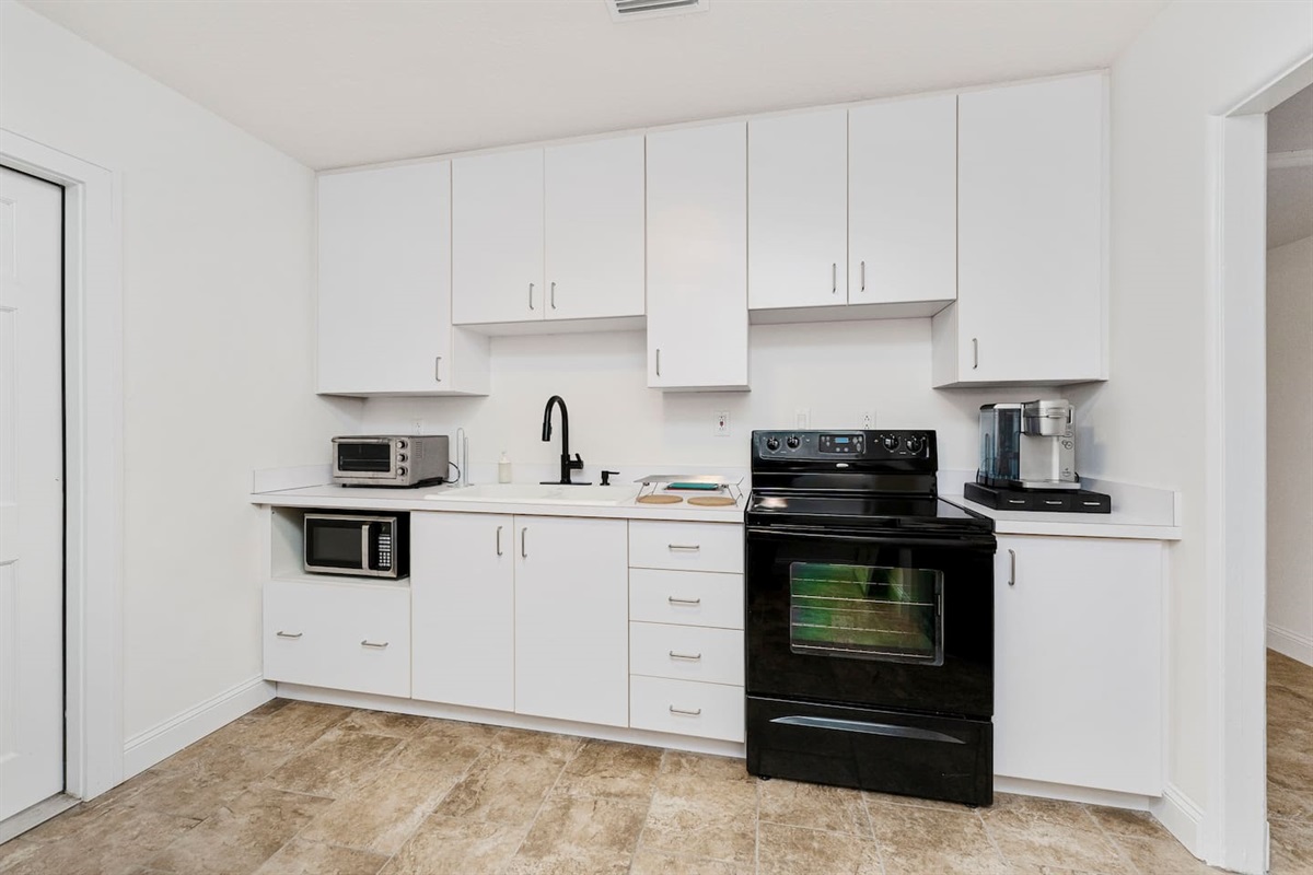 Sleek white kitchen ready for cooking & casual hangs