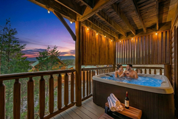 Your evening starts here — covered hot tub, Smoky Mountain sunset, and nowhere else you need to be. Pool towels provided for every guest.