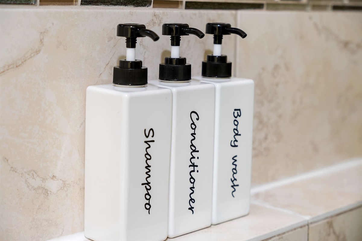 Discover the convenience of provided shampoo, conditioner, and body wash dispensers in the bathroom.