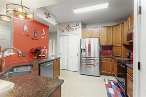 Spacious and well-equipped kitchen with modern appliances and a stylish red accent wall. Perfect for cooking up a feast or enjoying a quick meal.