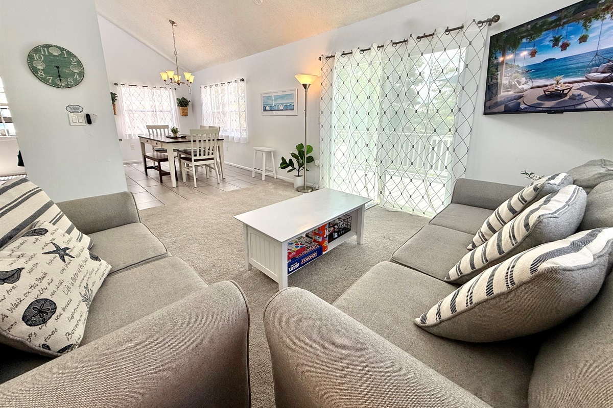 With its contemporary furniture, soft carpeting, and airy design, this living room offers both style and comfort for every guest.