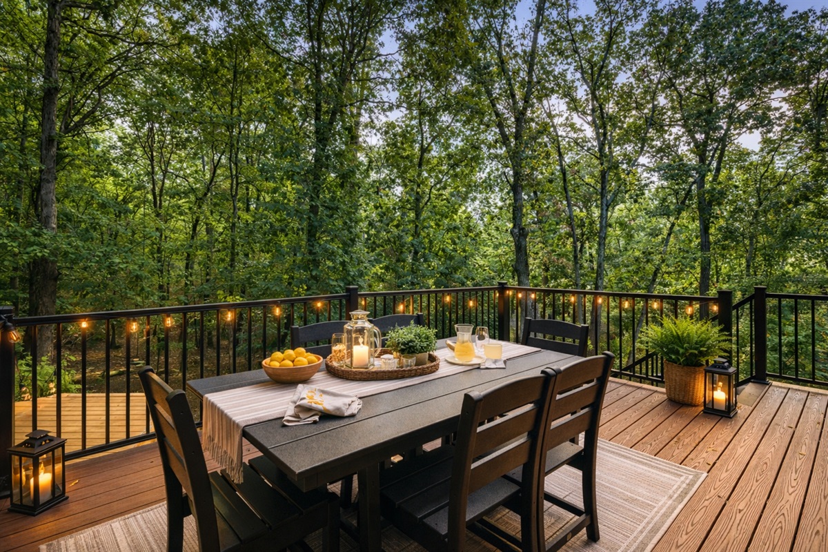 Dinner on the deck feels like eating in a treehouse — string lights overhead, forest canopy all around, and nowhere to be but right here.