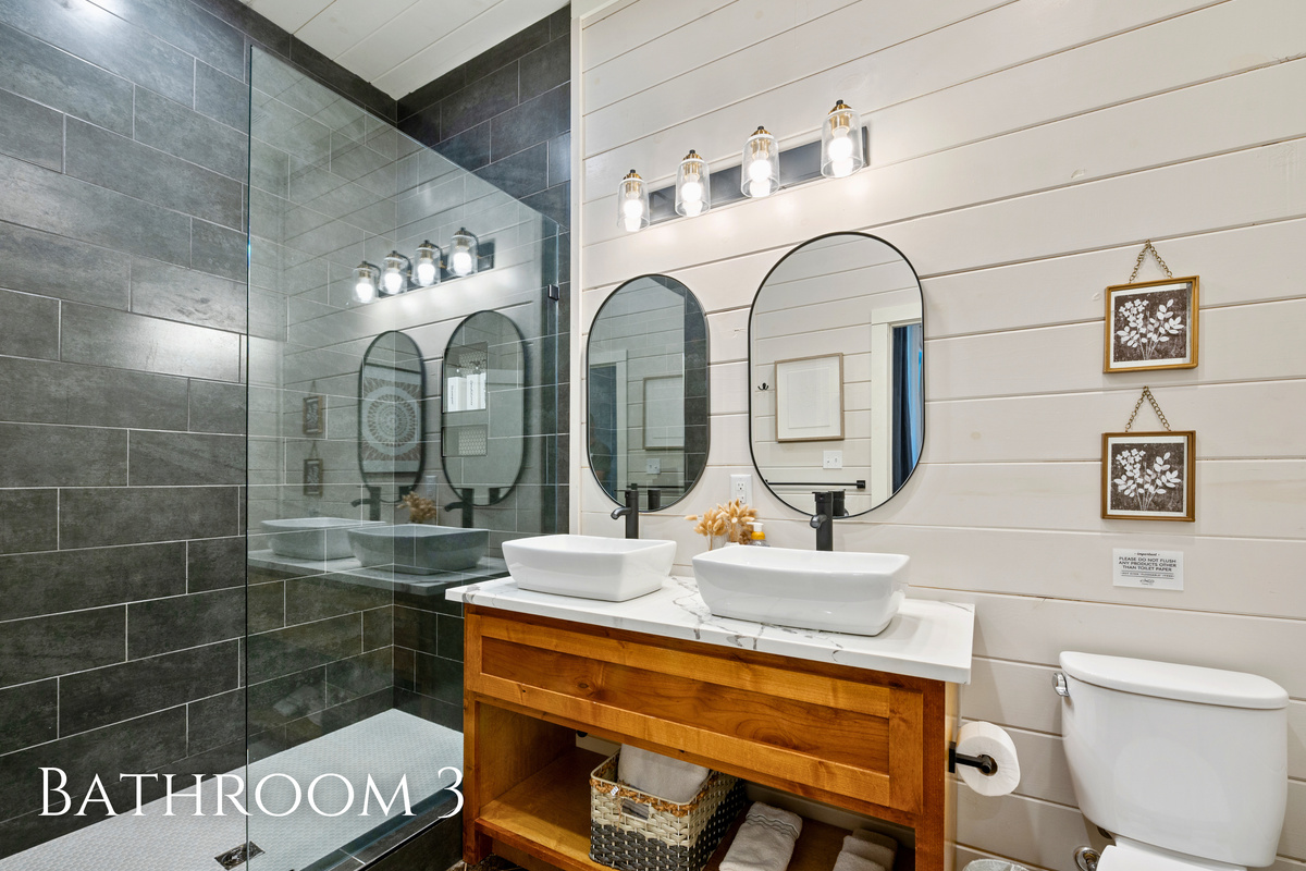 Dual vessel sinks and modern finishes give this bathroom both style and functionality for busy mornings.