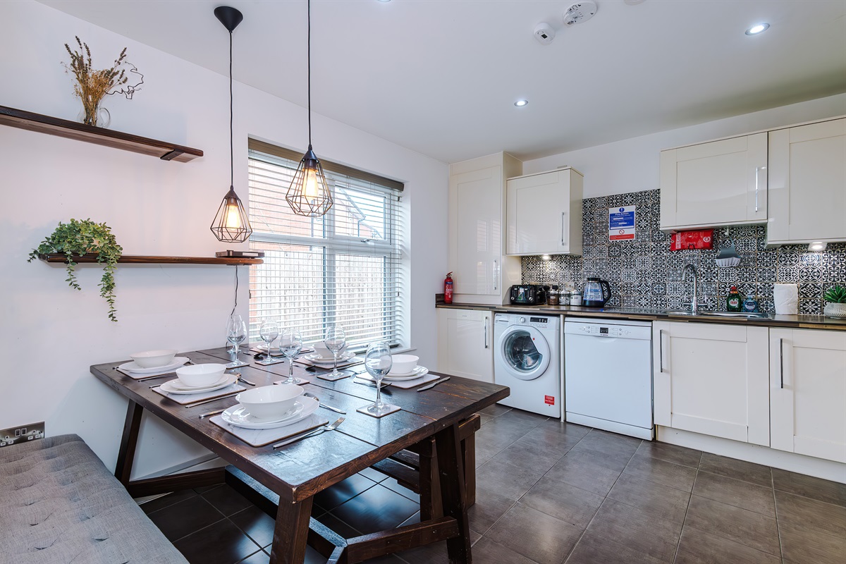 The bright and spacious kitchen benefits from a large dining table and cushioned benches