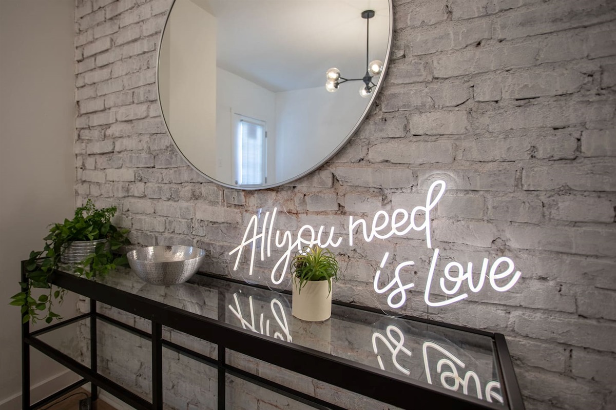 Large mirror with elegant wall décor, creating a striking focal point that enhances the room's sense of space and style.