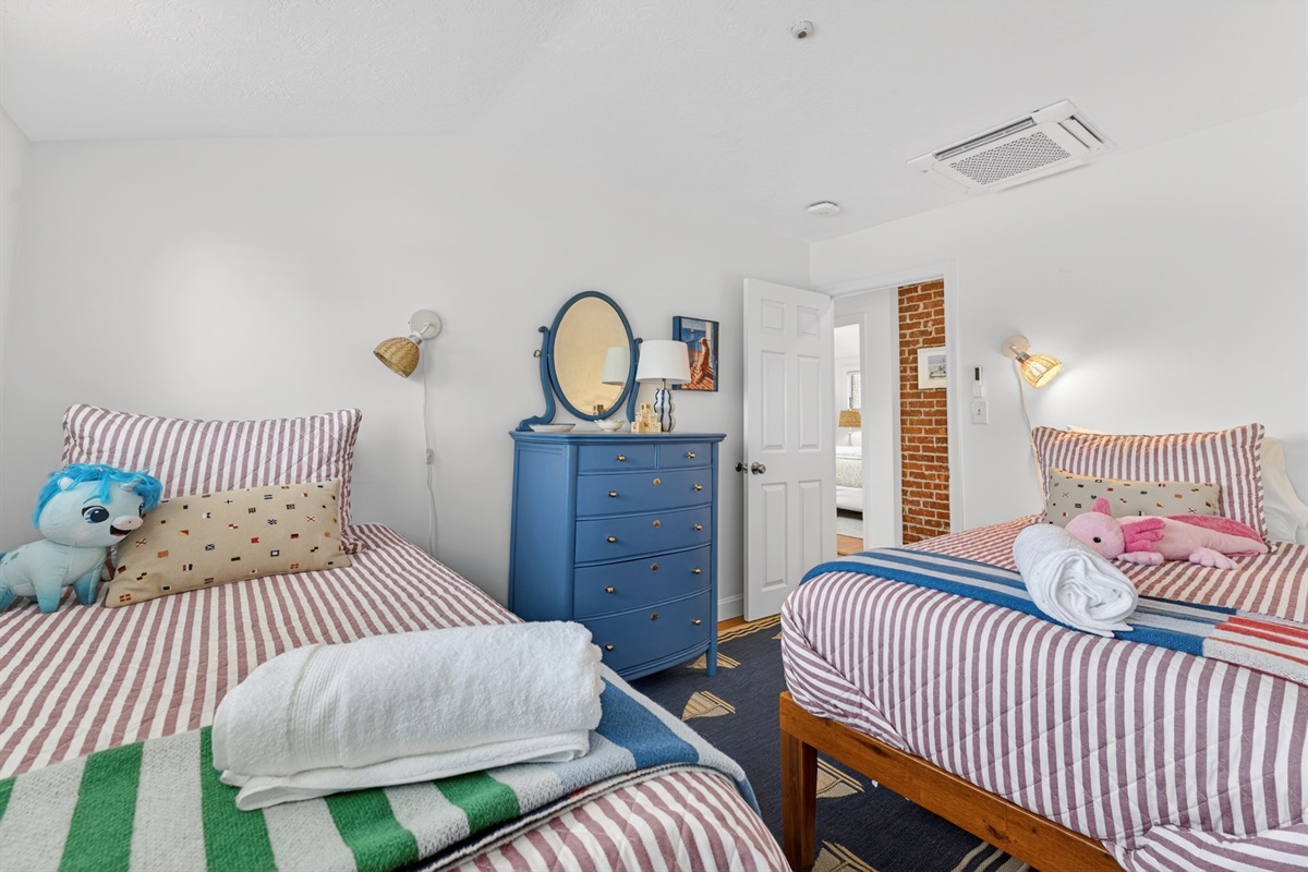 Cheerful twin bedroom with two beds and cozy coastal touches, ideal for kids or extra guests.