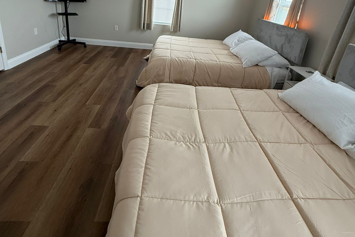 Another angle of 2 queen bed bedroom with TV