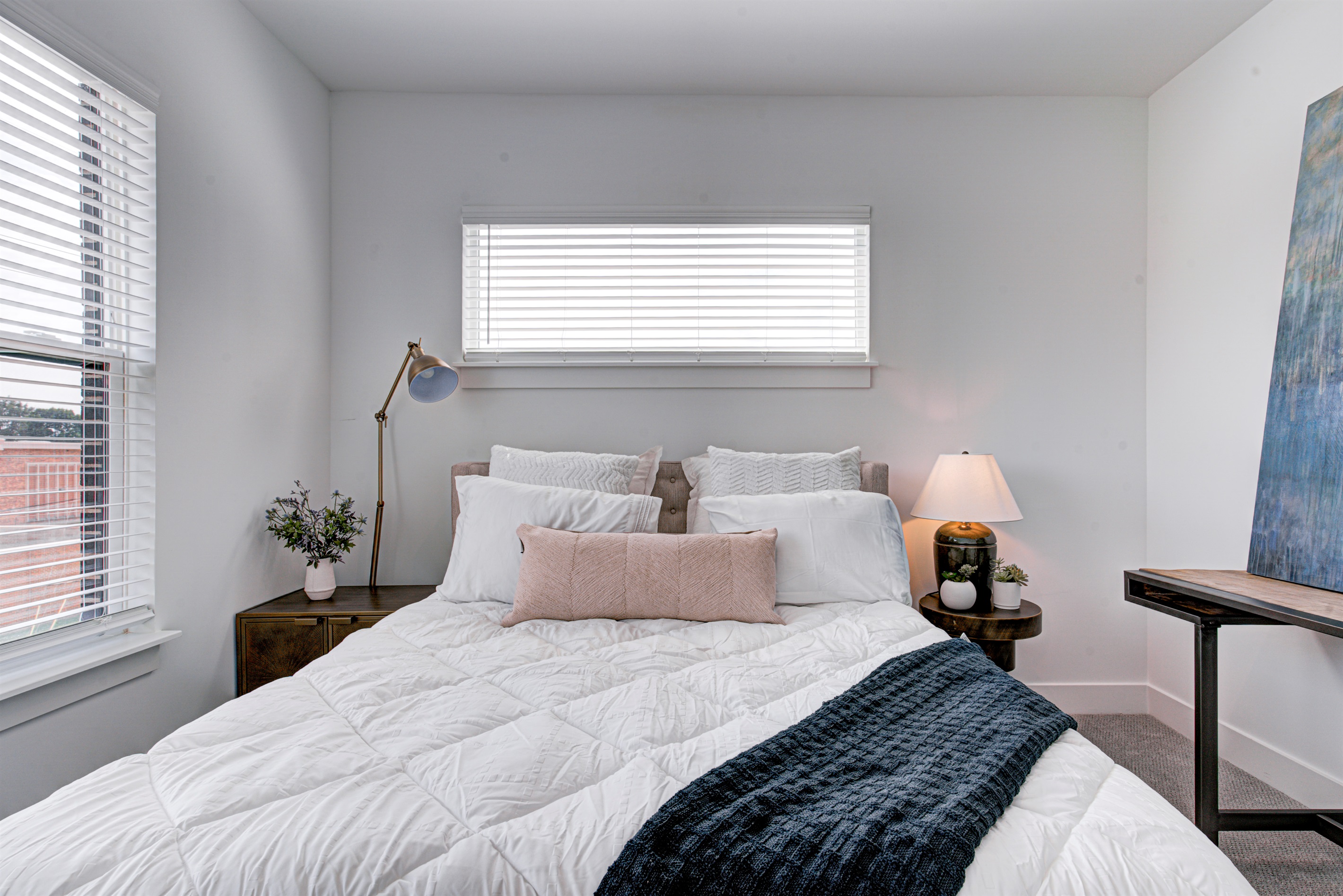 Relax in the serene master bedroom featuring a comfortable king-size bed, soft linens, and cozy pillows. Includes nightstands, lamps, walk-in closet, and full-length mirror for added comfort. 