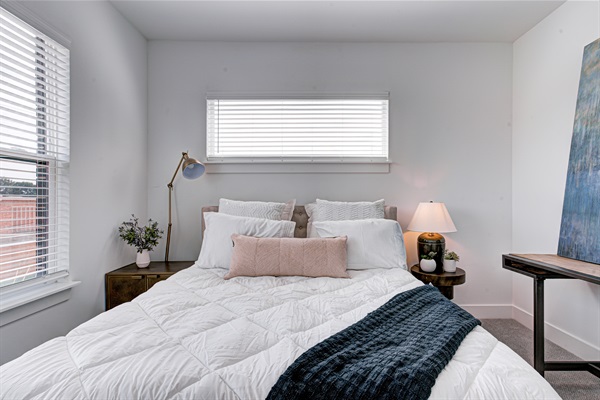 Relax in the serene master bedroom featuring a comfortable king-size bed, soft linens, and cozy pillows. Includes nightstands, lamps, walk-in closet, and full-length mirror for added comfort. 