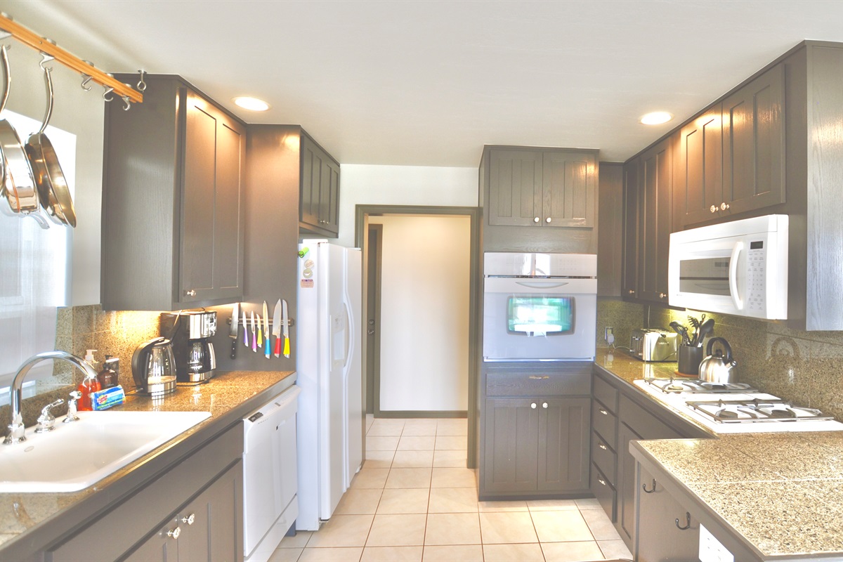 Full kitchen with gas range, electric oven, coffee maker, dishwasher, and refrigerator/freezer.