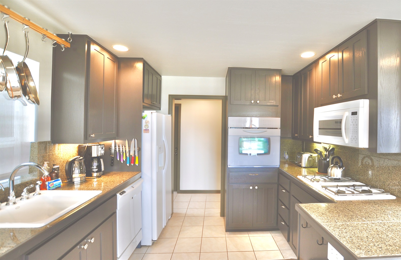 Full kitchen with gas range, electric oven, coffee maker, dishwasher, and refrigerator/freezer.