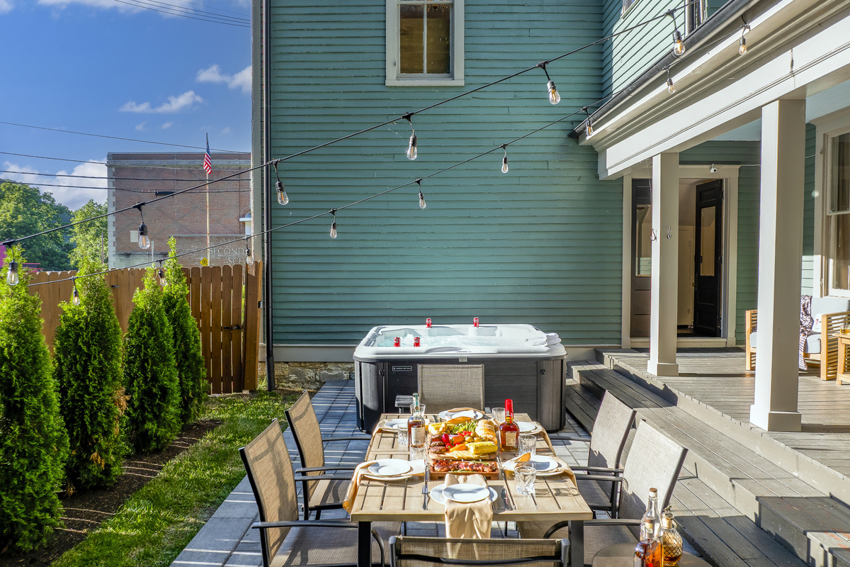 The private back patio brings outdoor dining and hot tub soaking side by side under open Kentucky sky.