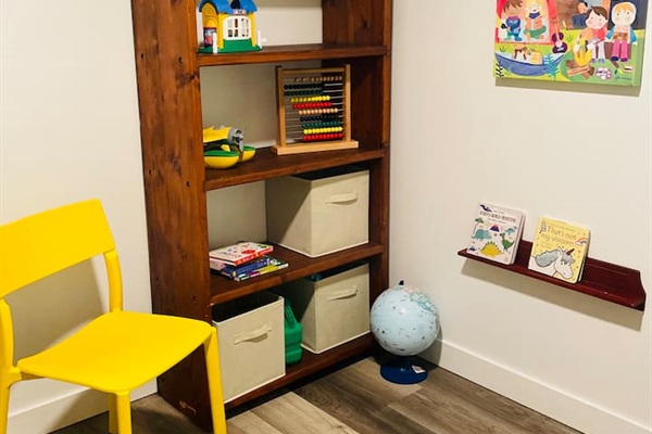 A playful corner filled with books, toys, board games, and puzzles creates a welcoming space where kids can explore, imagine, and enjoy hours of fun.