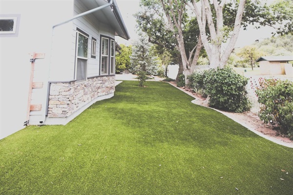artificial turf back yard with hanging lights