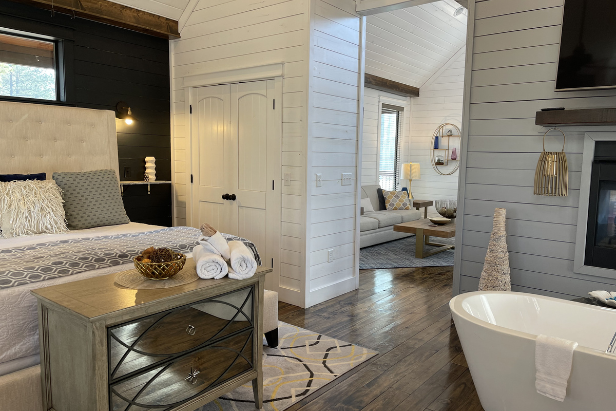 Master bedroom, king size bed and full soaking tub in front of the see through fireplace.