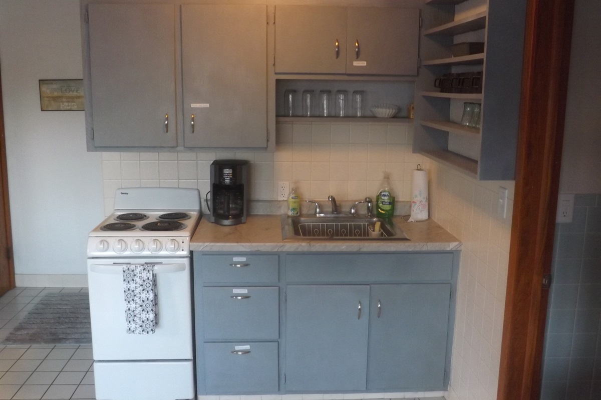 Full kitchen with refrigerator, stove, microwave, coffee makers, and most essentials