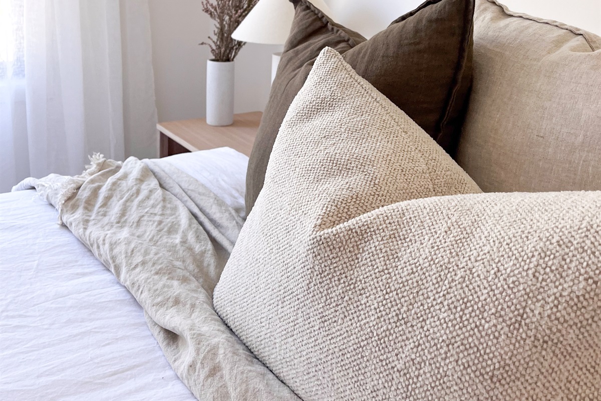 The pillow detail shows the calm neutral styling used through the bedroom spaces at Summers Green View Retreat.
