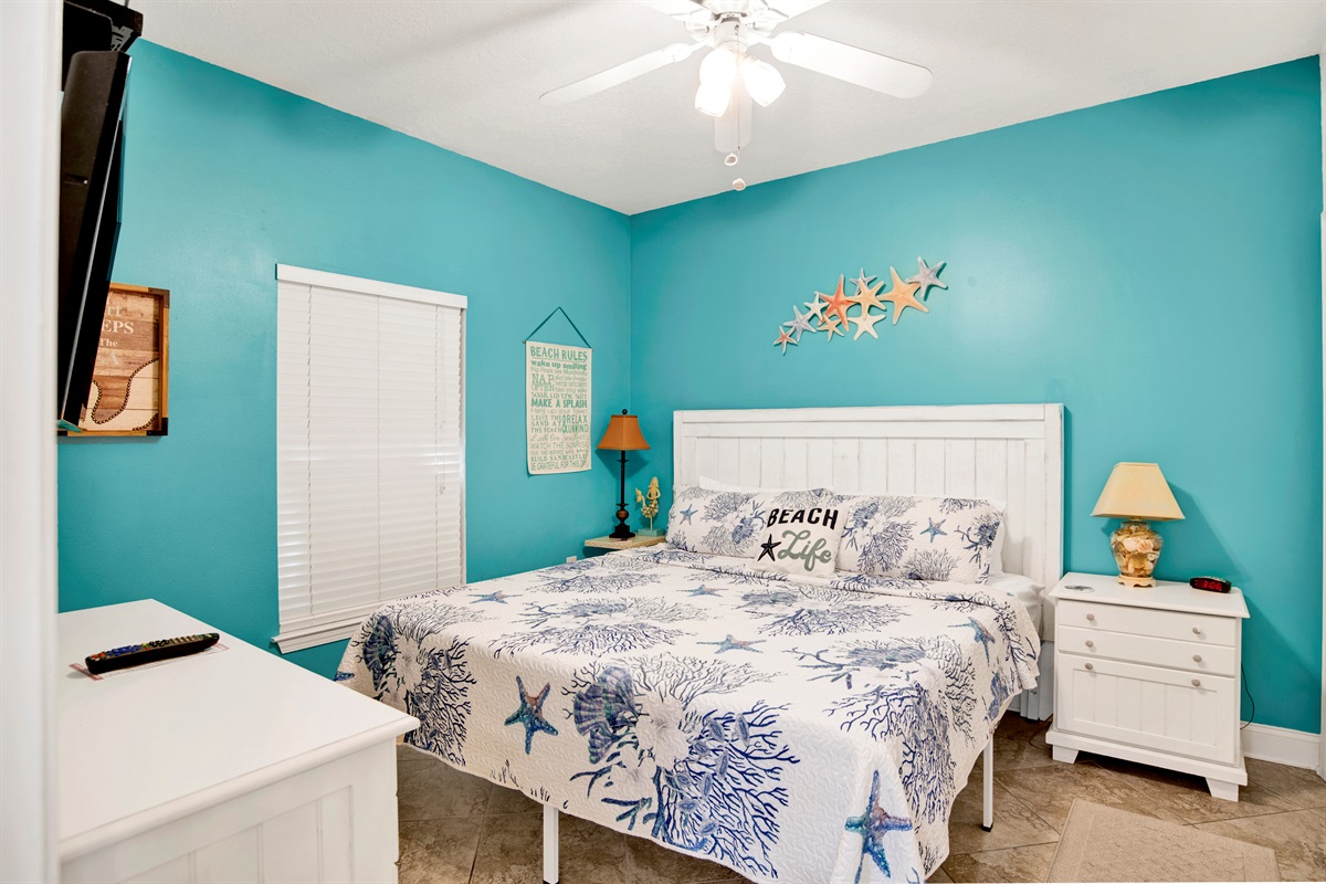 2nd bedroom with king bed, dresser, wall mounted 40" tv with a firestick, ceiling fan, 2 nightstands and direct main bathroom access through door in the bedroom