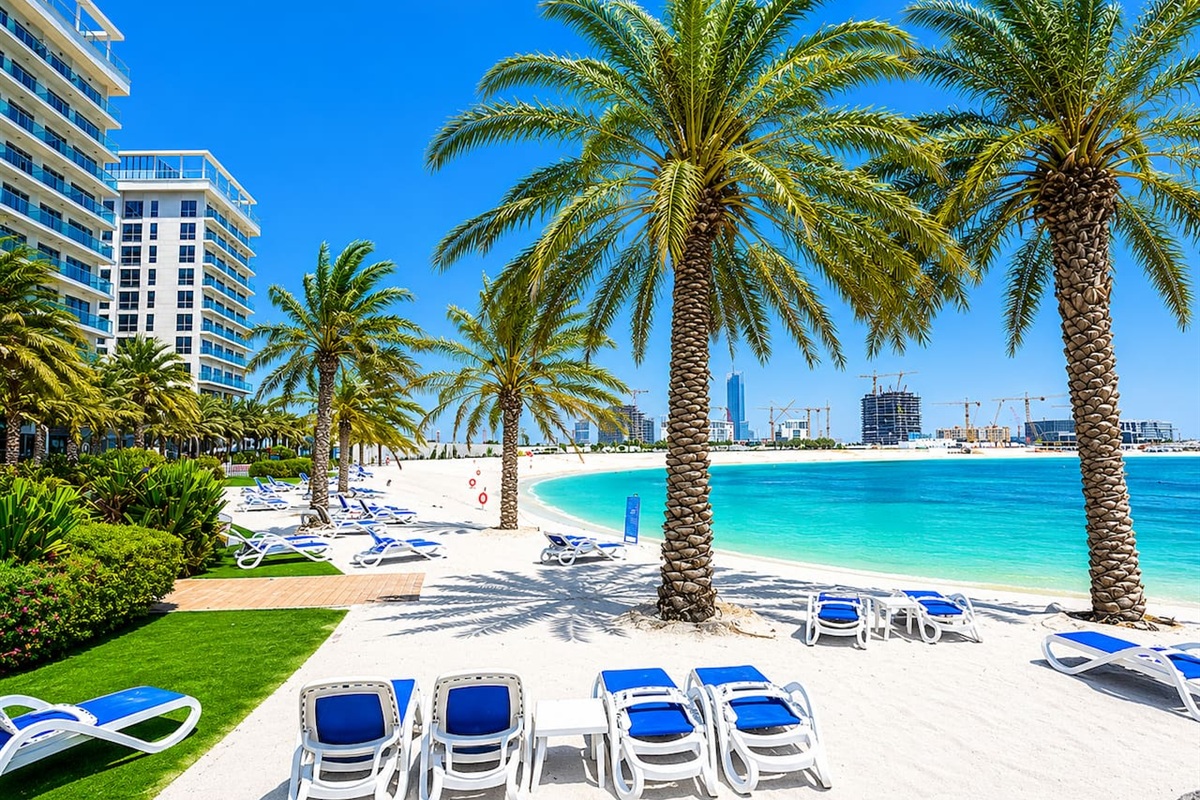 Relaxing beach with sunbeds and umbrellas free for guests surrounded by clear sea water