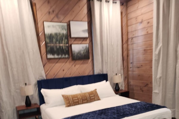 Spacious king bedroom with warm wood finishes and cozy charm.