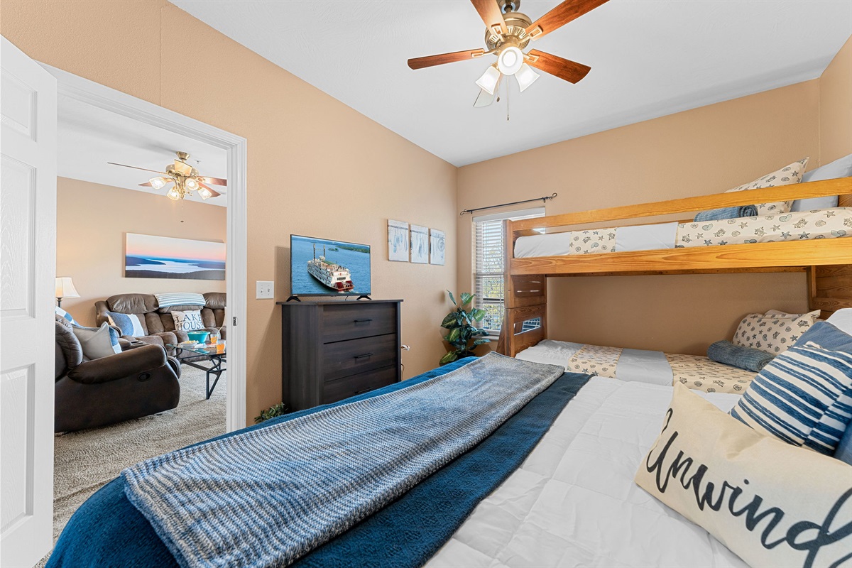 The bunk room has a dresser and a smart tv to enjoy
