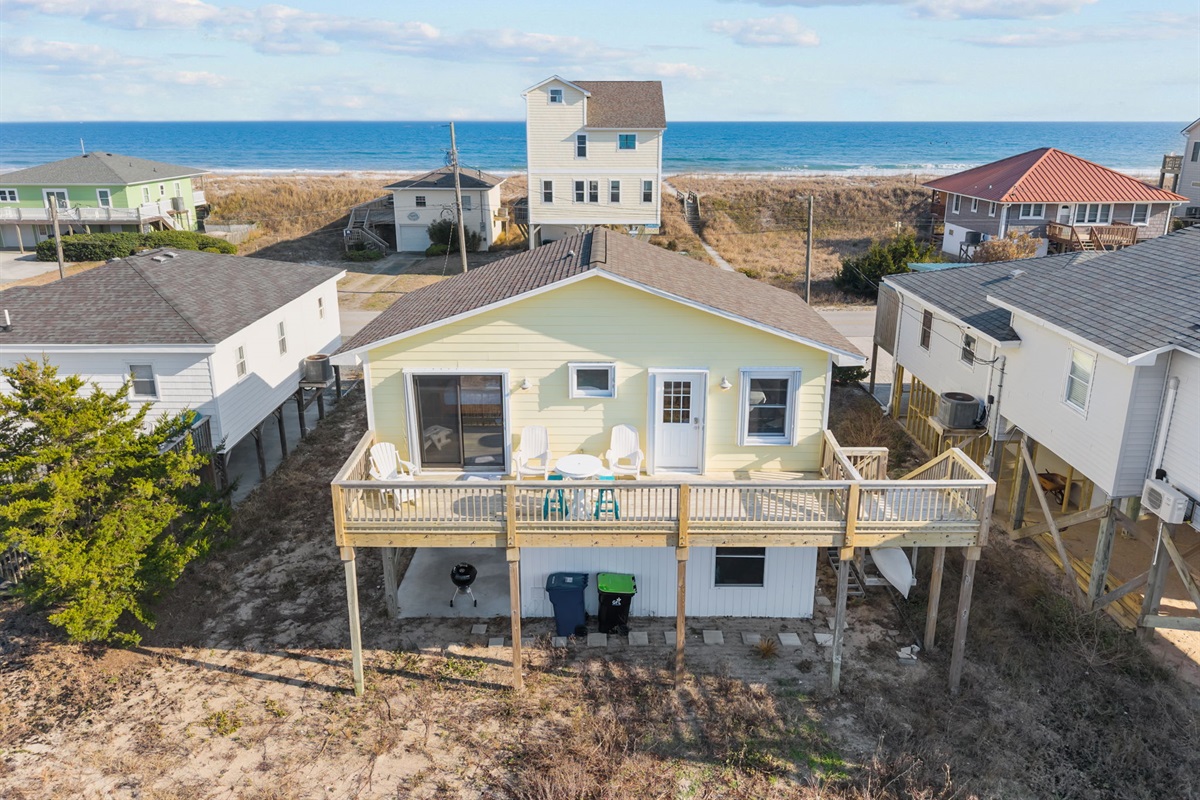 Aerial view showcasing the home&rsquo;s prime location just steps from the beach, with sweeping ocean views behind