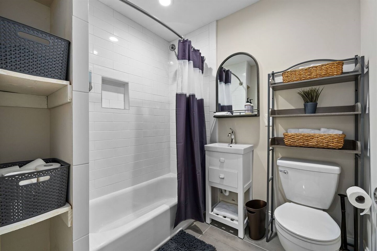 Modern and sleek, equipped with a contemporary tub and shower and essential amenities.
