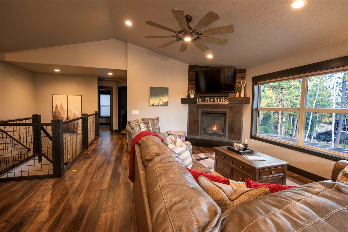 Imagine relaxing in the welcoming living room at "On The Rocks," where the fireplace's gentle fire creates a cozy ambiance.