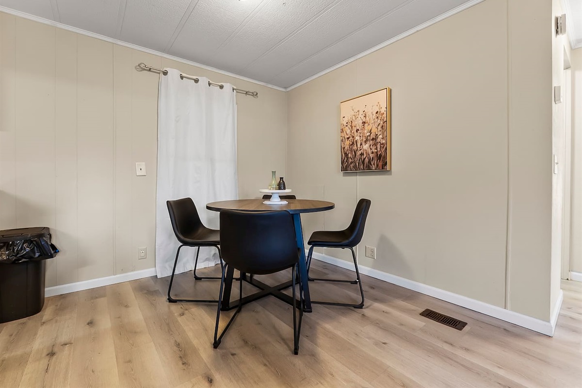 Modern round dining table with sleek chairs, offering a comfortable space to gather.