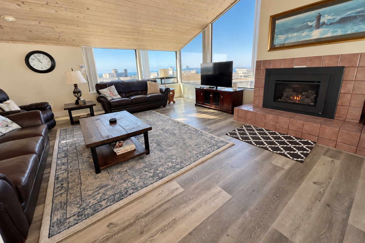 Living Rm with comfortable couches, fireplace, large picture windows and cable-TV/Roku