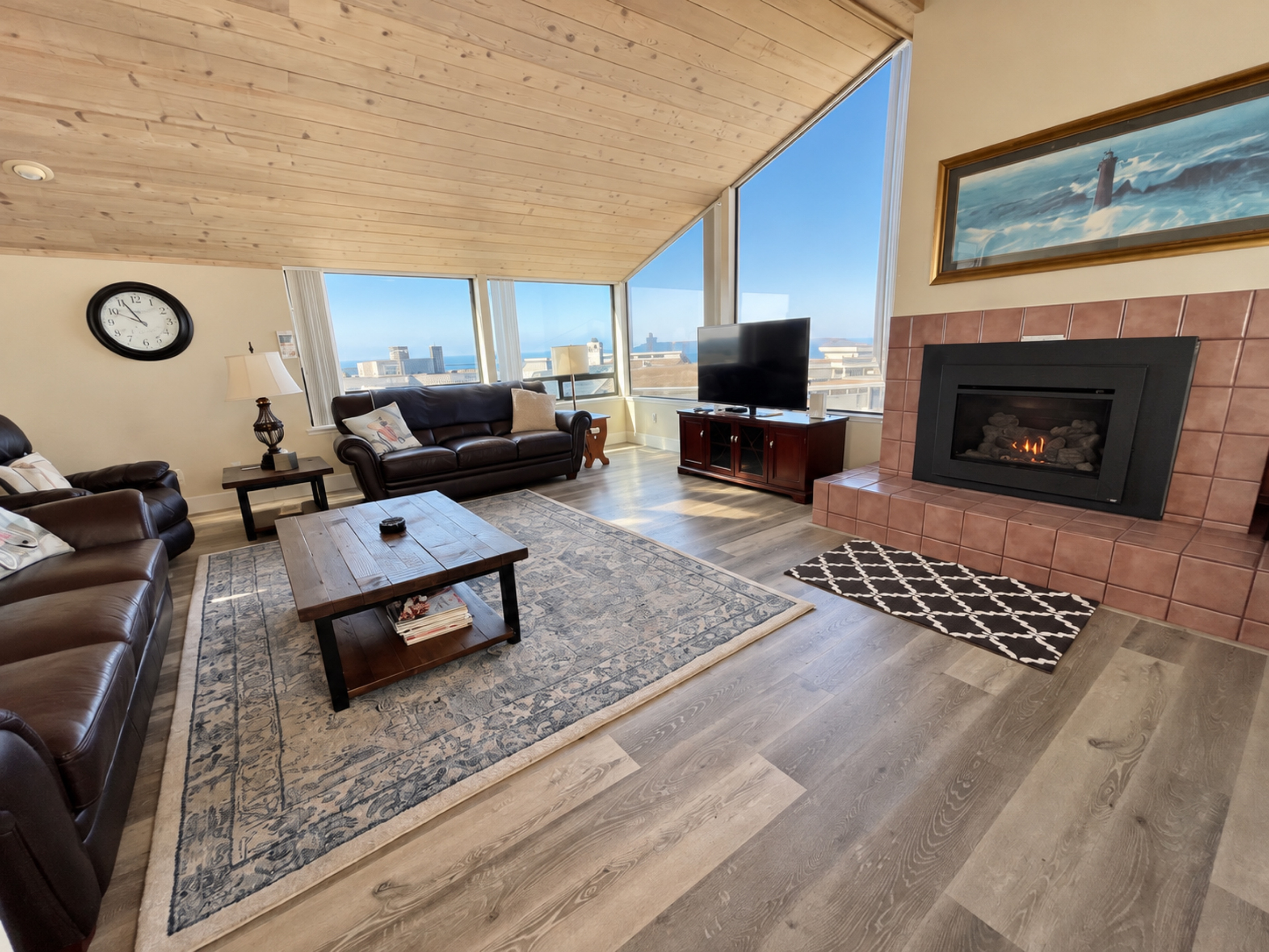 Living Rm with comfortable couches, fireplace, large picture windows and cable-TV/Roku