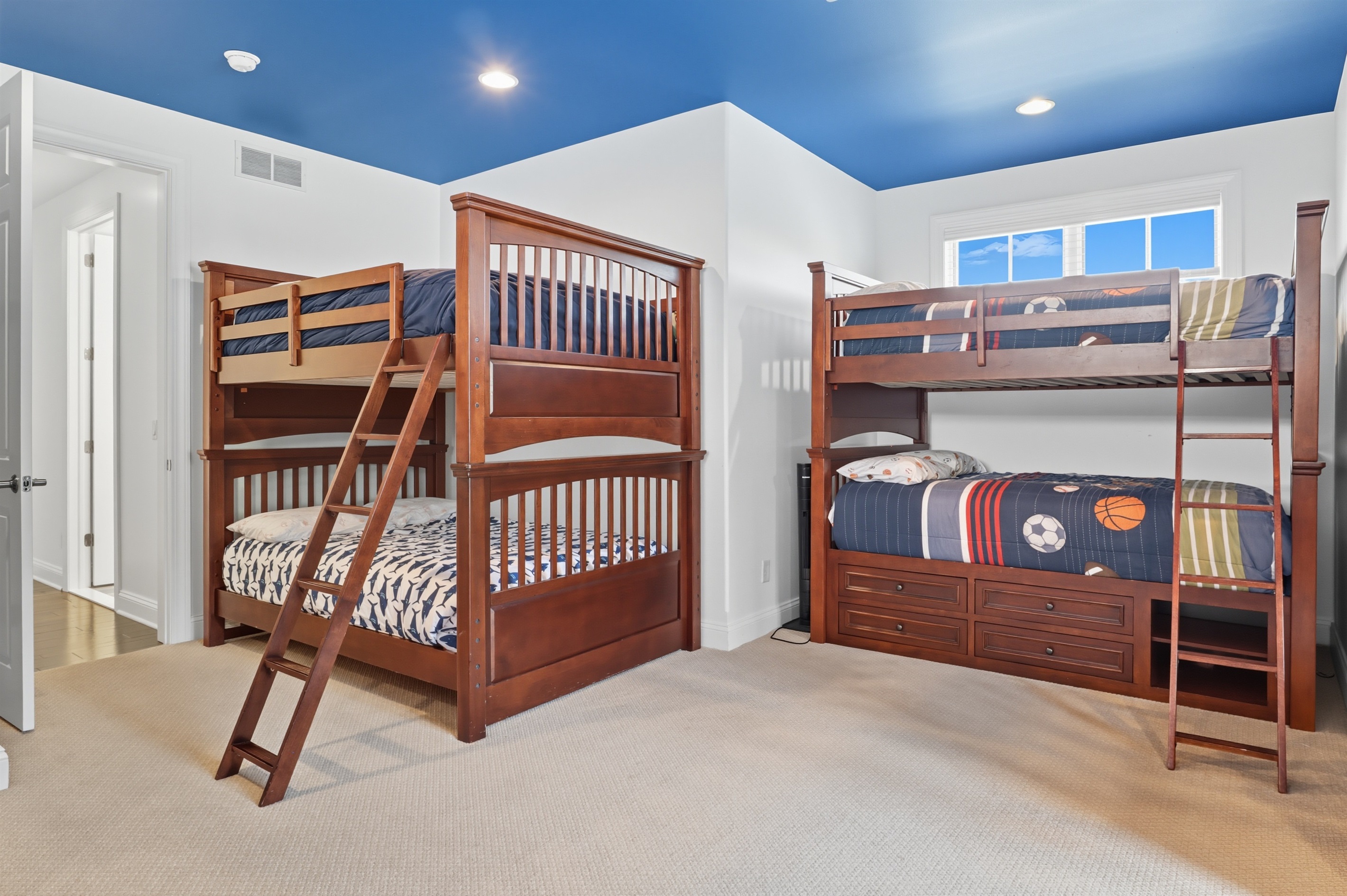 Spacious upstairs bunk room with 3 bunks featuring full mattresses on top and bottom and 2 bunks with twin mattresses on top and bottom. Bedroom #5