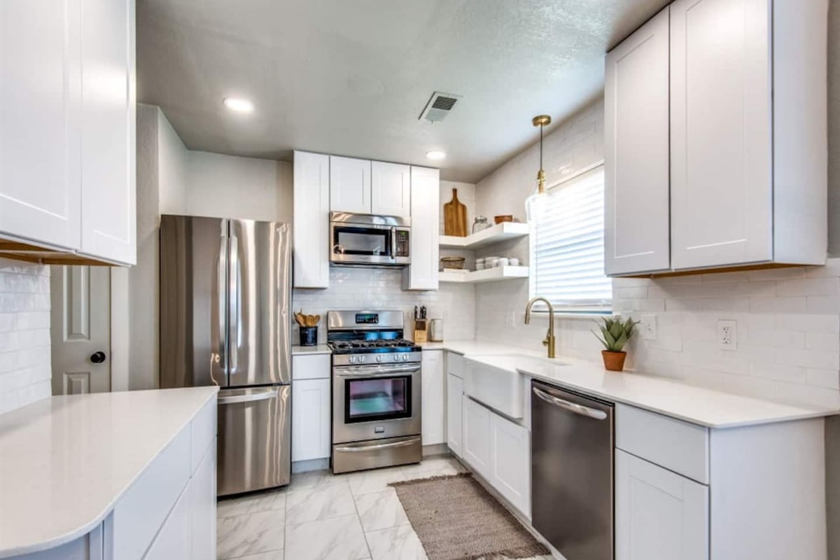 Renovated kitchen with stainless steel appliances, white shaker cabinets, and quartz countertops. Stocked with Keurig, blender, cookware, and dishes. Modern farmhouse Airbnb in Aubrey TX near Frisco, Denton, and wedding venues.