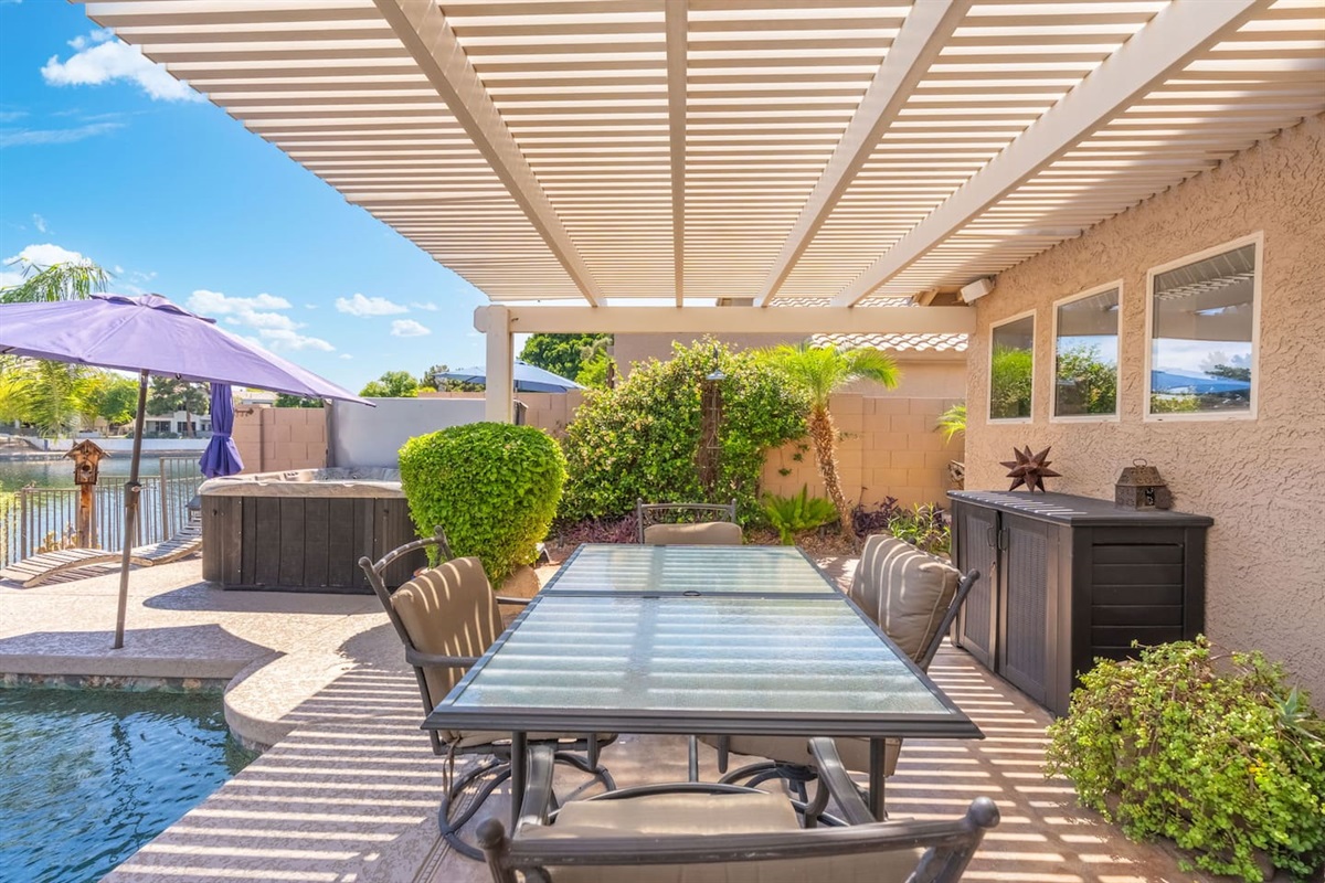 With the hot tub tucked just beyond the landscaping and the lake glimmering in the background, this pergola dining spot puts you right in the heart of everything the backyard has to offer.