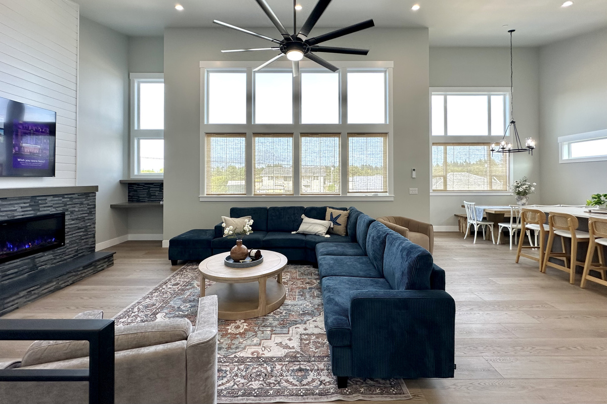 Step in from the upstairs entry and the whole main level opens up — living, dining and kitchen in one bright, window-wrapped space. This is Side A of a brand-new 2026 duplex, and it books on its own or right alongside Side B.